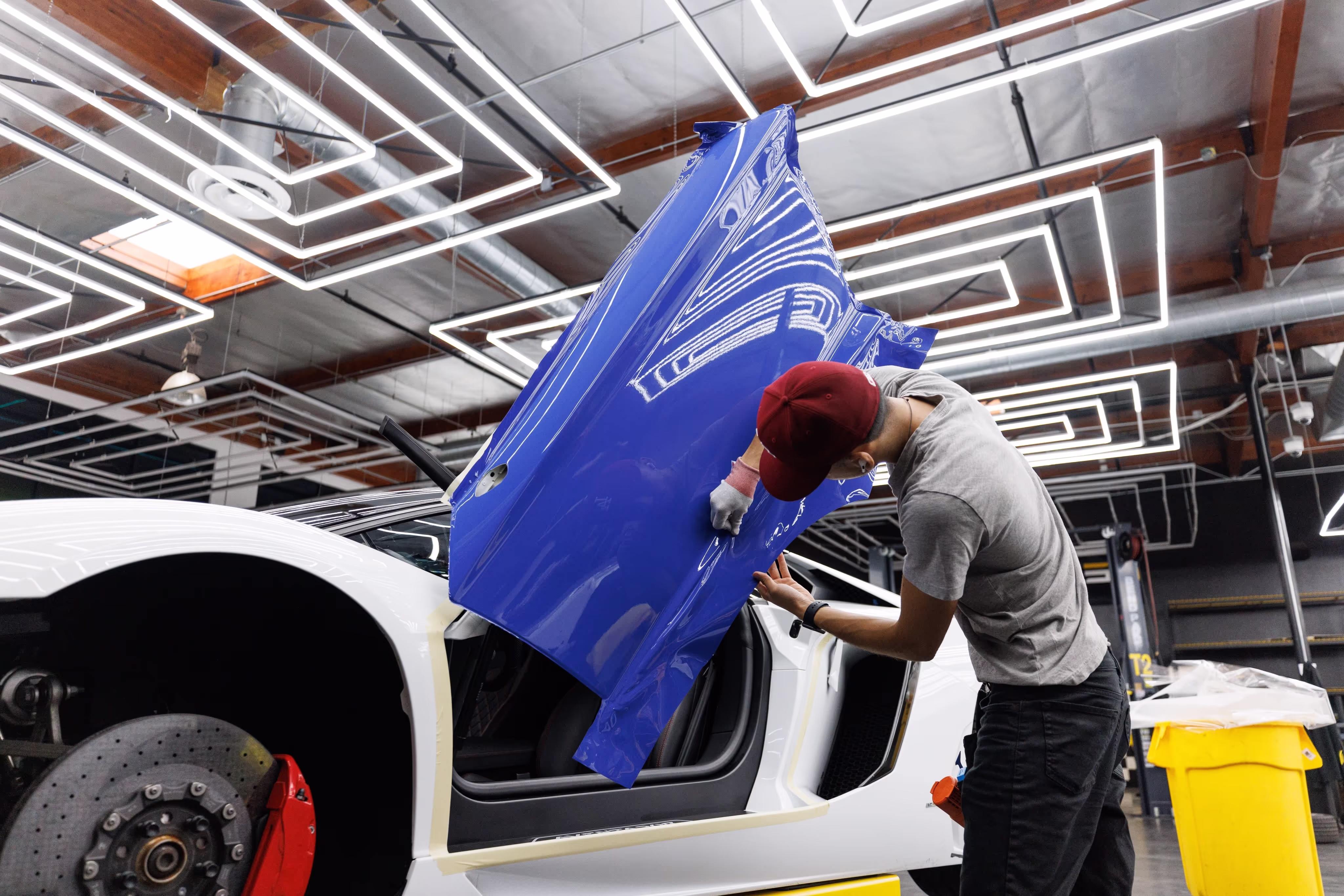 A wrapping specialist installing vinyl wrap onto a vehicle