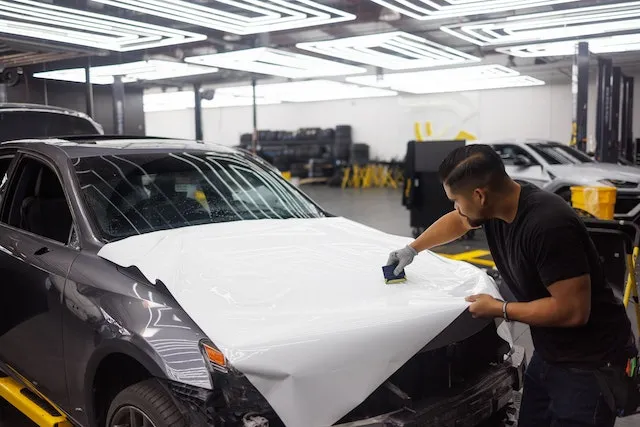 A man installing vinyl wrap to a vehicle showcasing a vinyl wrap service offered by Wrap Daddy's